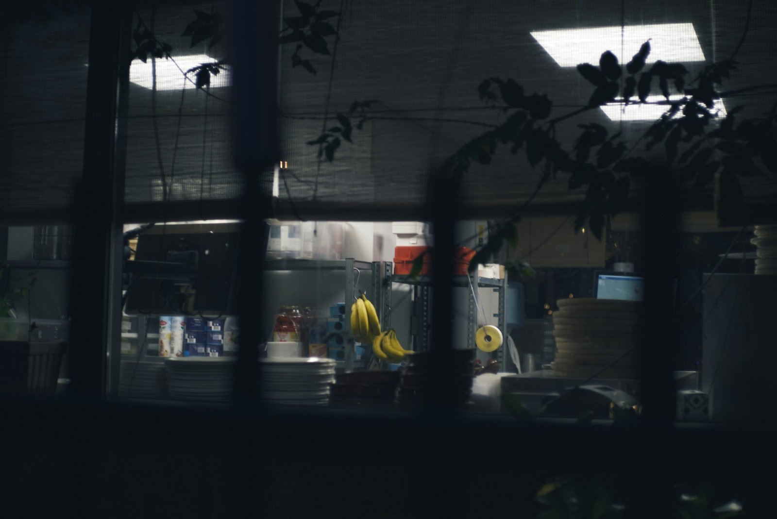 A view of a kitchen through a window at night