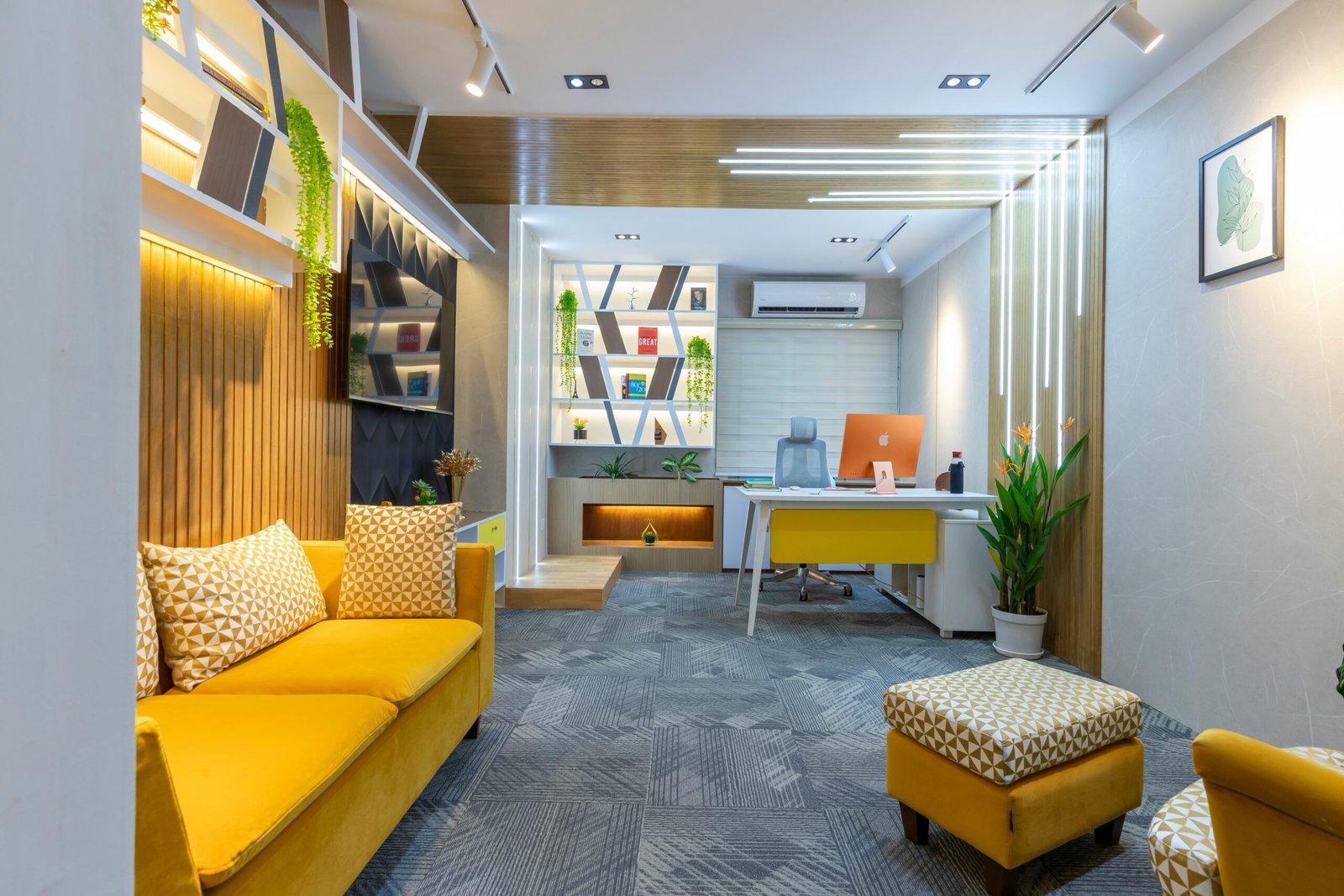 a yellow couch sitting in a living room next to a desk