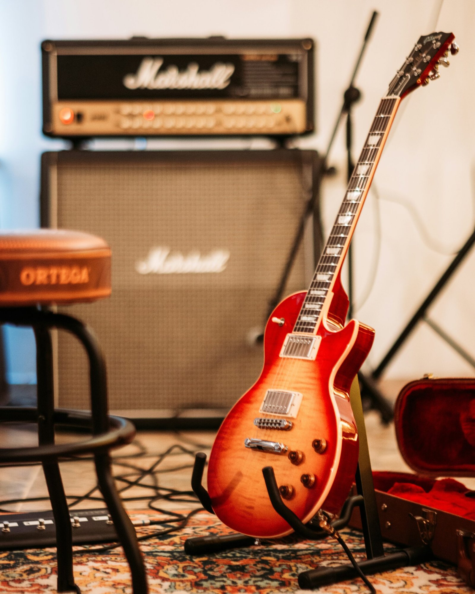 a red guitar sitting on top of a rug